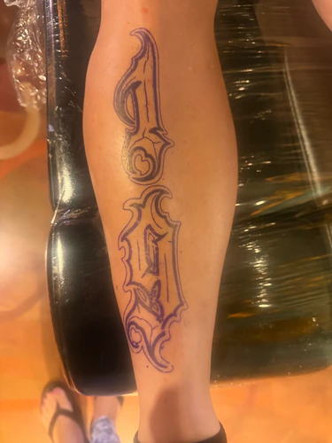 The 1979 leg lettering tattoo in progress in Chyloe's chair at Golden Tarot Ink Club