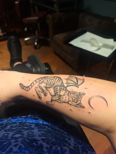 Side view of the winged cat memorial forearm tattoo by Victoria