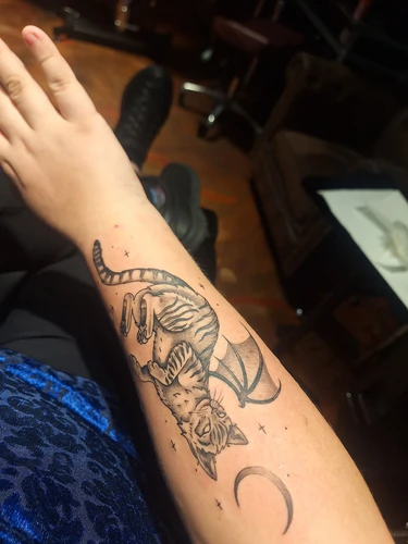 Winged cat memorial forearm tattoo by Victoria at Golden Tarot Ink Club