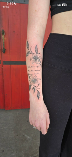 Fine line flowers with a handwritten script quote, a forearm tattoo by Chyloe at Golden Tarot Ink Club